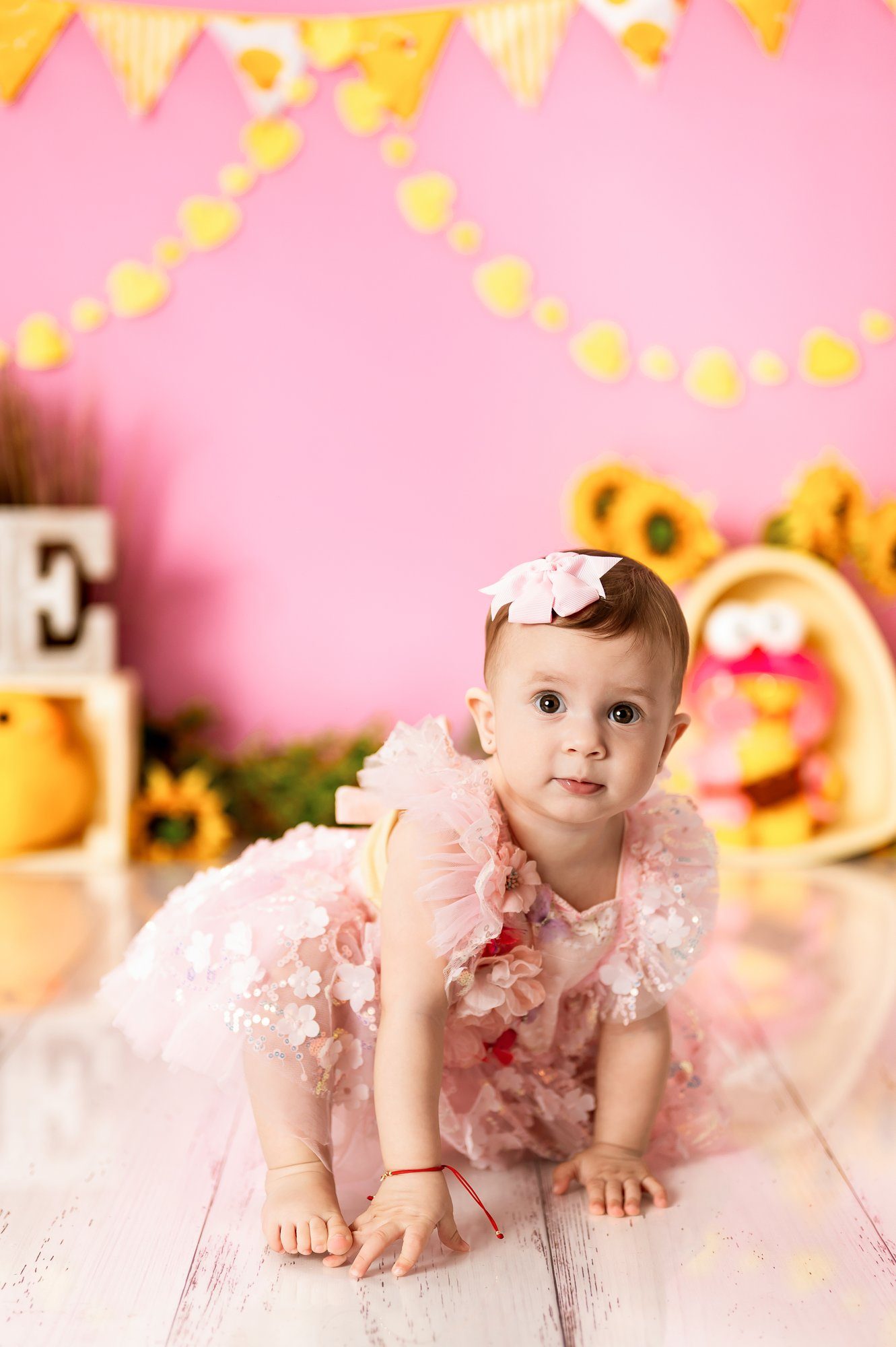 Dad holding baby girl in pink outfit during family cake smash photo session