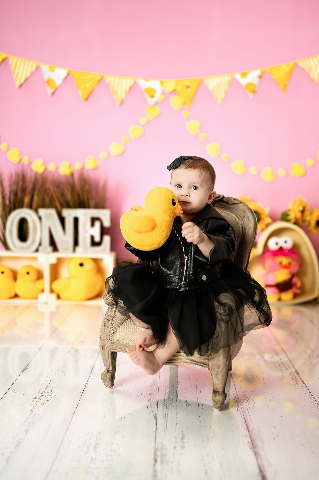 Baby girl crawling in pink lace dress during cake smash photography with sunflowers