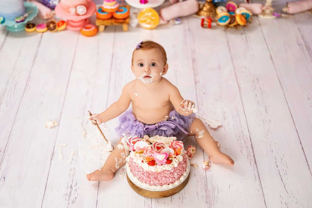 Toddler covered in cake during cake smash photography session at Mihai Gonguta studio Milton Keynes