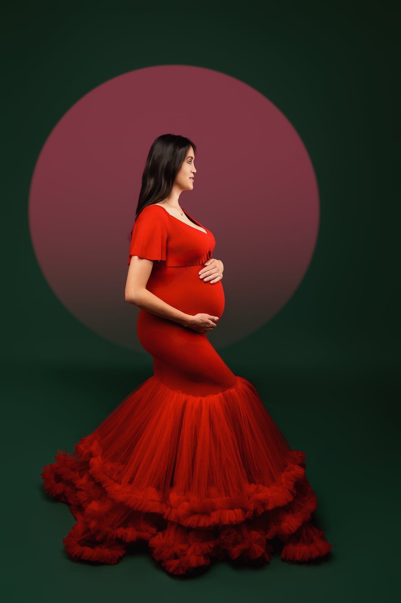 Pregnant woman posing with cream feathered angel wings in starry studio setting with reflection