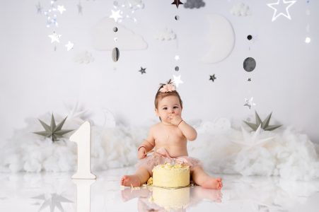 Baby girl covered in frosting and sprinkles