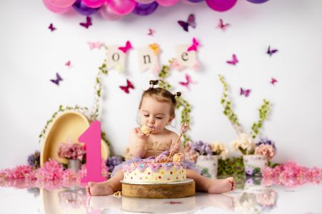 Baby girl covered in frosting and sprinkles