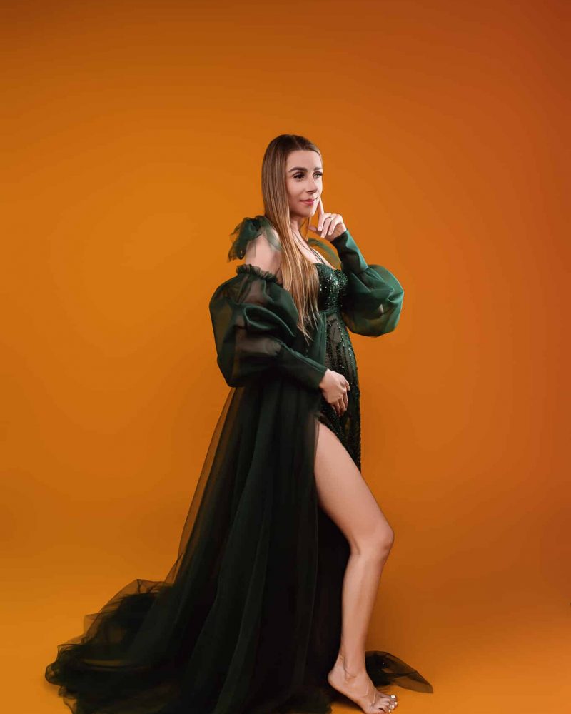 Floor-length maternity gown with flowing fabric for bump photography