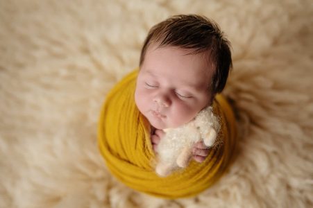 Newborn baby wrapped in yellow fabric