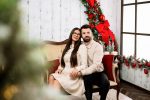 Couple seated on a cream sofa in the Elegance Christmas set by the window