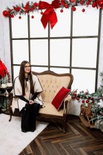 Woman seated on a cream tufted sofa by a tall window, Elegance Christmas set