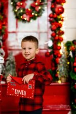 young boy in red plaid shirt smiling by white Christmas trees Christmas photography Northampton